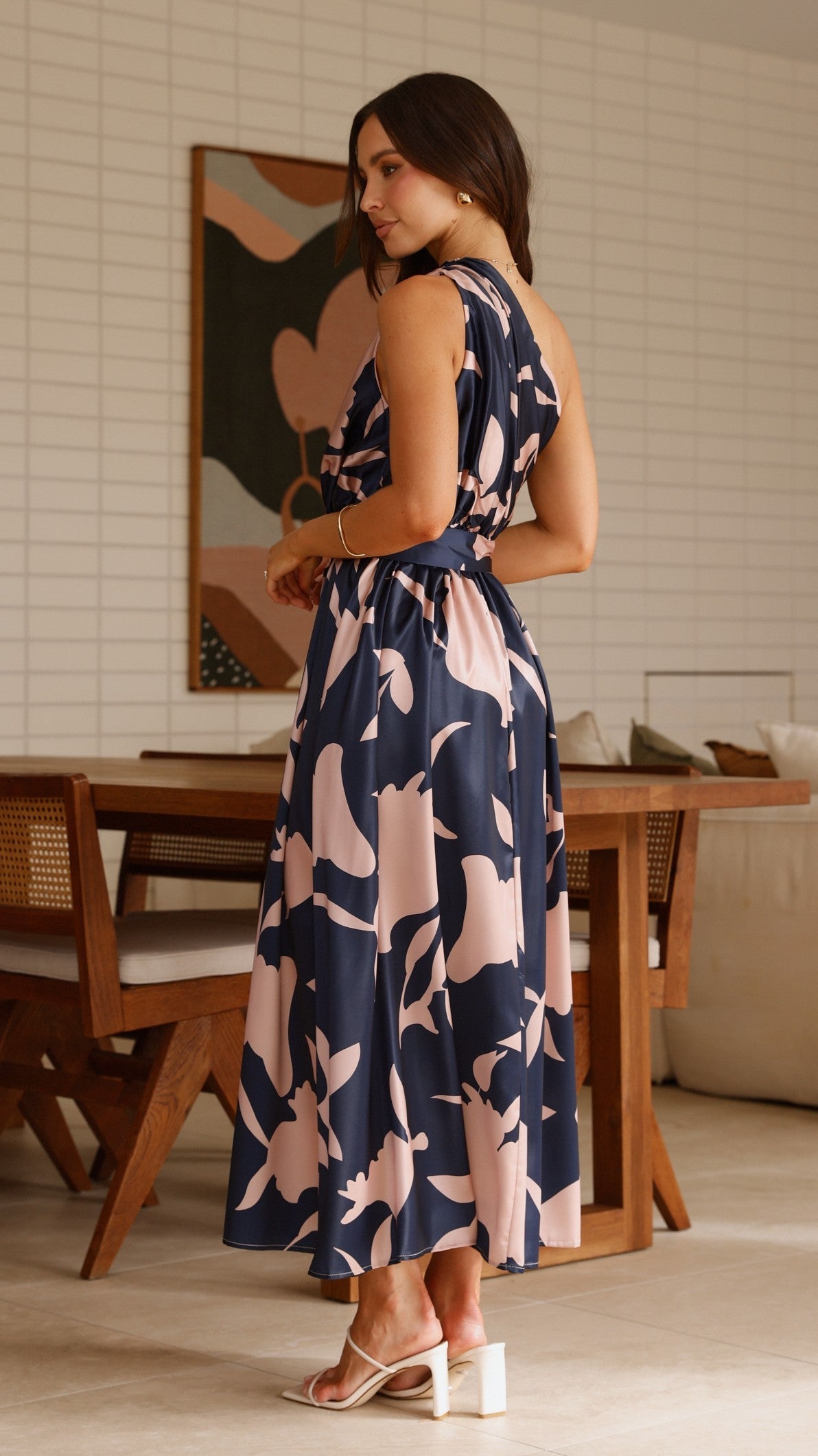 Navy sleeveless maxi dress with pink abstract floral print and tie waist belt, side view