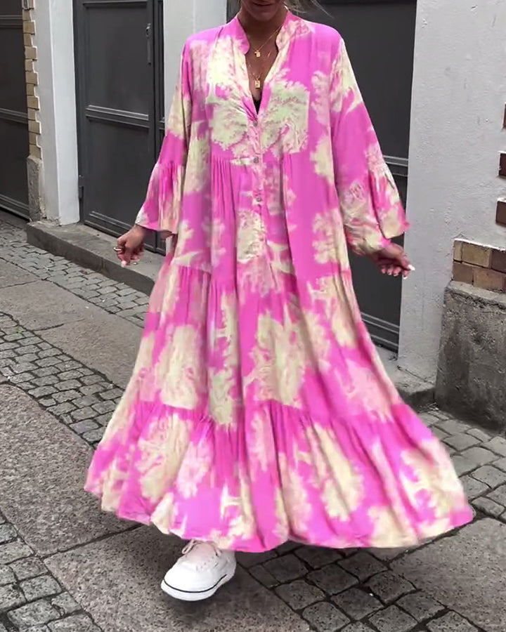Bright pink long-sleeve maxi dress with cream and green abstract print, tiered skirt.