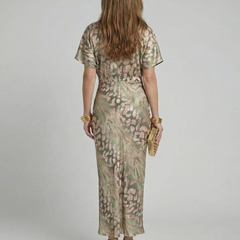 Back view of green abstract print midi dress with twisted waist and short sleeves