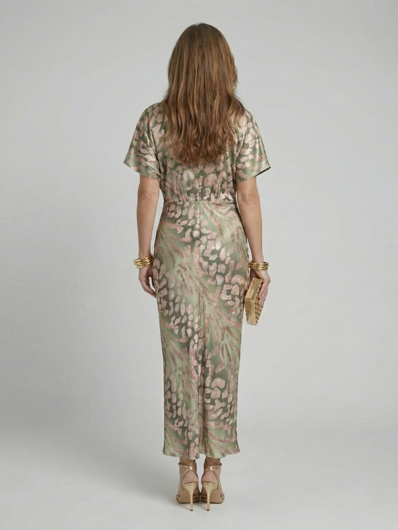 Back view of green abstract print midi dress with twisted waist and short sleeves