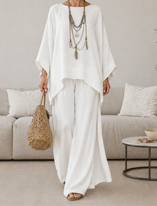 White two-piece set with draped tunic top and wide-leg pants, long sleeves.