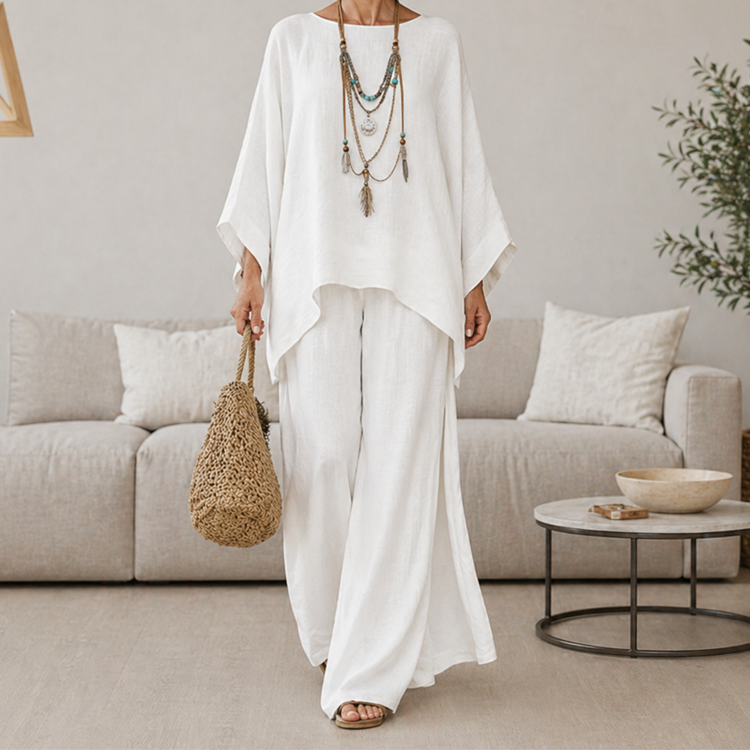 White two-piece set with draped tunic top and wide-leg pants, long sleeves.