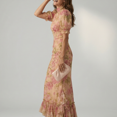 Floral pink high-neck maxi dress with gathered waist, puff sleeves, and ruffled hem.