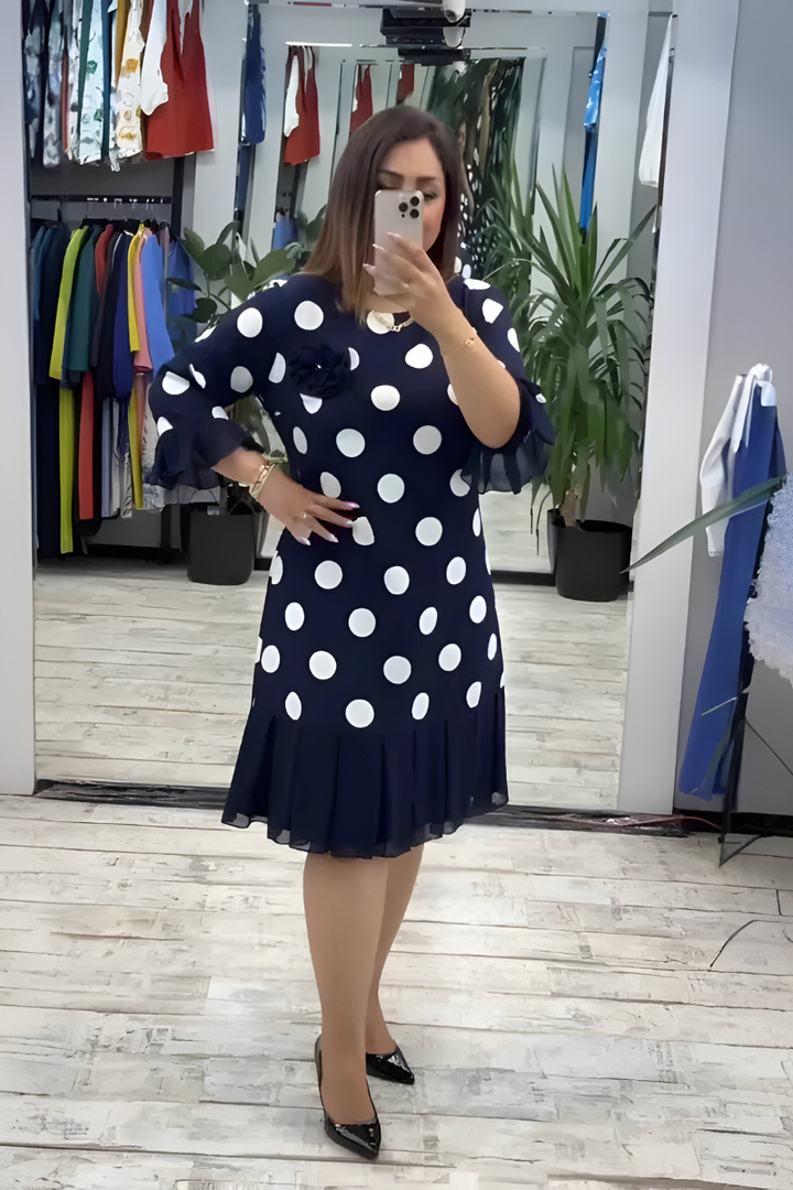 Navy midi dress with white polka dots, ruffled short sleeves, and pleated hem