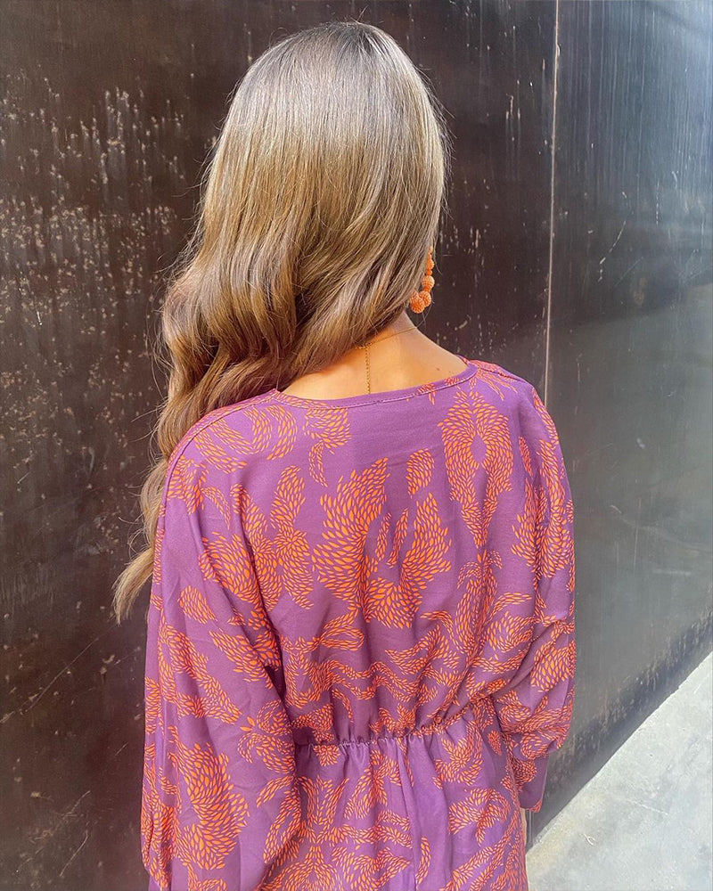Back of elegant summer dress, purple with orange leaf print, gathered waist, long sleeves