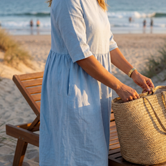 Light blue midi dress with gathered waist and three-quarter sleeves, side view