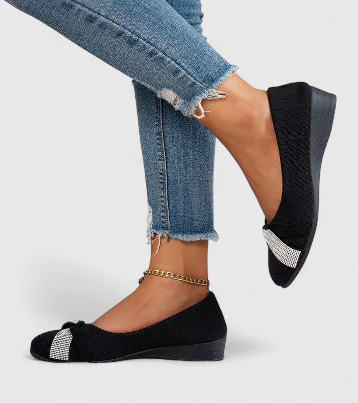 Black orthopedic slip-on flats with silver glitter band across the toe
