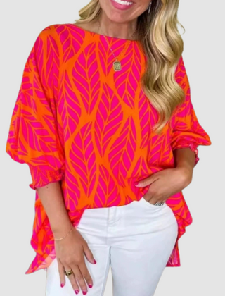 Loose red-orange leaf-print blouse with relaxed short sleeves and rounded neckline
