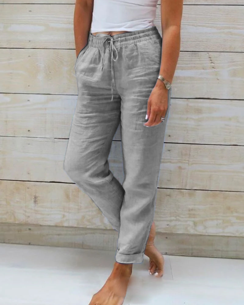Grey cotton trousers with drawstring waist and tapered leg cuffs