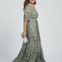 Sage green V-neck halter maxi dress with floral print, short sleeves and tiered flowy skirt