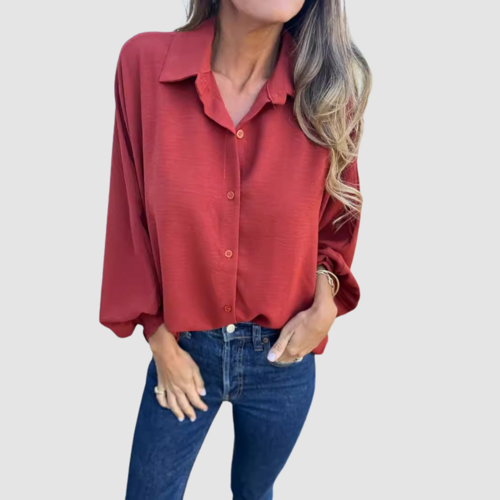 Oversized red button-up blouse with pointed collar and long sleeves, loose drape.