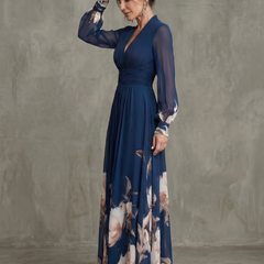 Navy wrap-style pleated maxi dress with long sheer sleeves and floral skirt