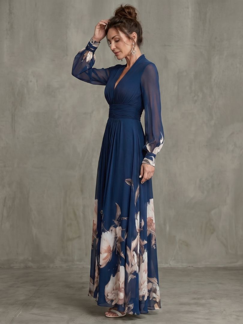 Navy wrap-style pleated maxi dress with long sheer sleeves and floral skirt