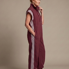 Burgundy zip-front jumpsuit with white side stripes and striped shoulder cuffs