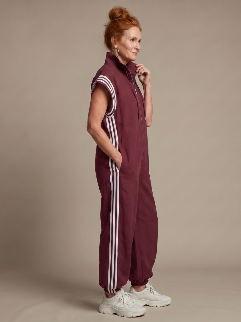 Burgundy zip-front jumpsuit with white side stripes and striped shoulder cuffs