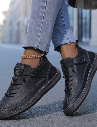 Orthopedic comfort sneaker in black with lace-up and double strap detail.