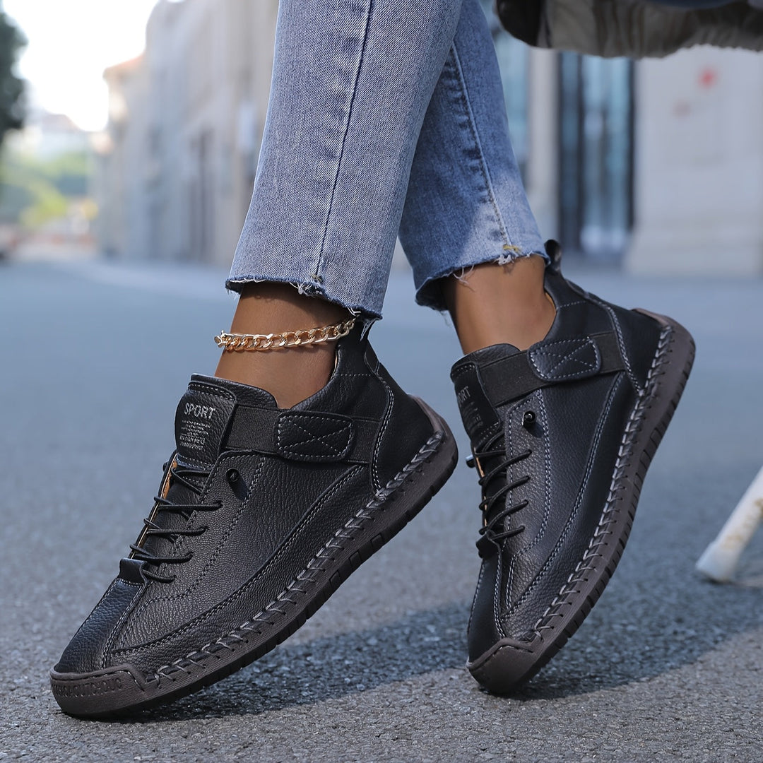 Orthopedic comfort sneaker in black with lace-up and double strap detail.