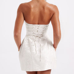 White strapless jacquard mini dress, open back with crisscross lacing and tied knot