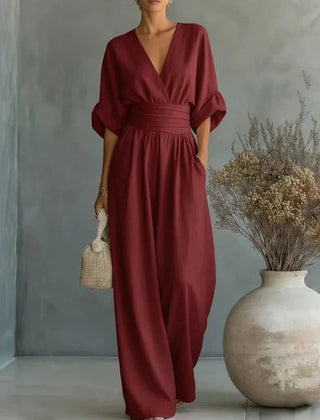 Burgundy V-neck wide-leg jumpsuit with elastic tie waist and loose dolman sleeves