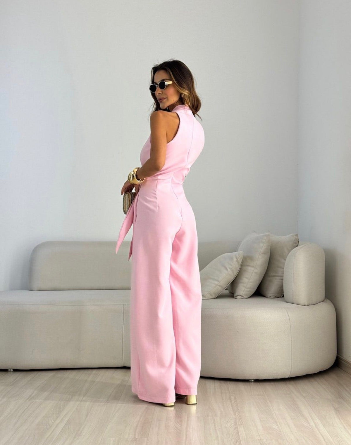 Pink sleeveless halter jumpsuit with waist tie and wide-leg pants
