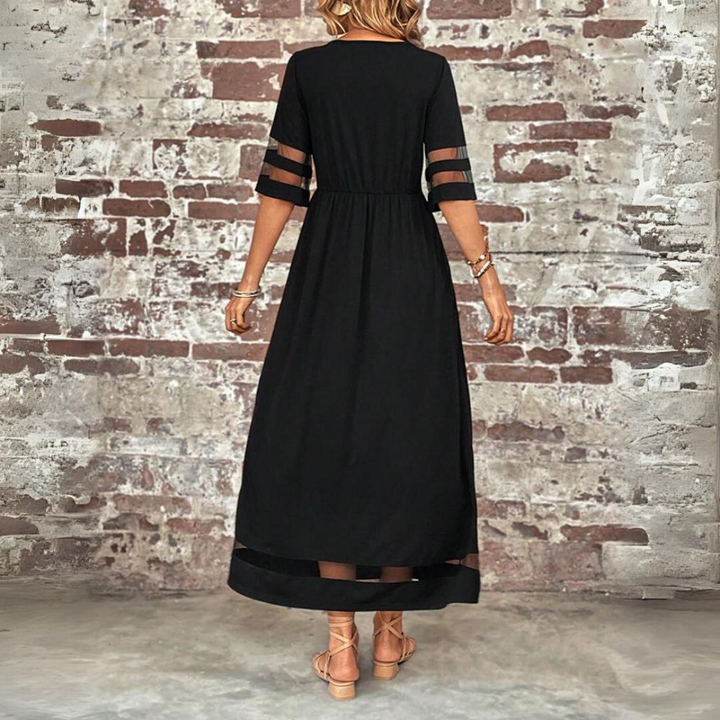 Black A-line midi dress, back view, elbow sleeves with sheer stripe trim at hem