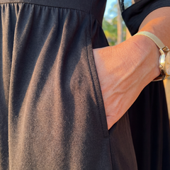 Black midi dress close-up: gathered waist and side seam pocket