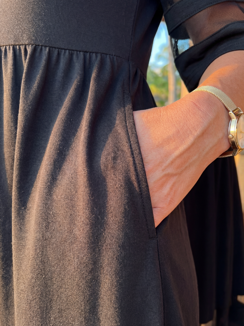 Black midi dress close-up: gathered waist and side seam pocket