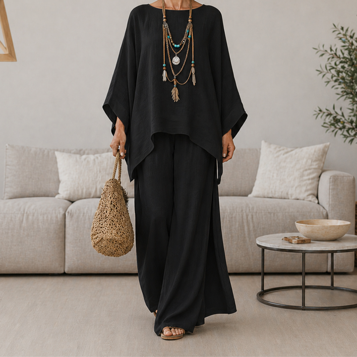 Black two-piece set with draped tunic top and wide-leg pants, long sleeves.