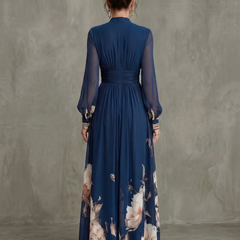 Navy maxi dress with pleated back, long sheer sleeves, and floral hem print