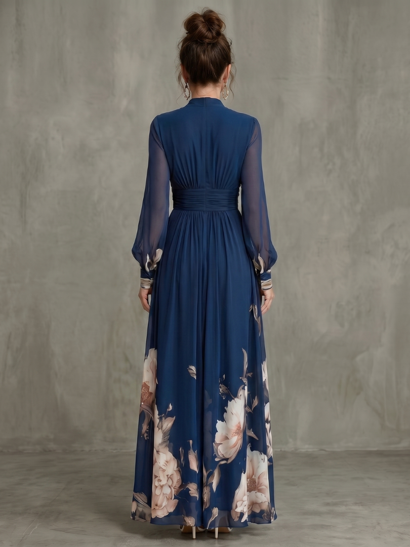 Navy maxi dress with pleated back, long sheer sleeves, and floral hem print