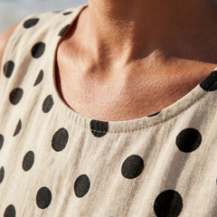 Cream sleeveless dress neckline with black polka dots detail