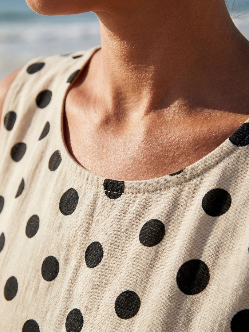 Cream sleeveless dress neckline with black polka dots detail