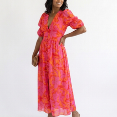 Pink floral V-neck midi dress with puff sleeves and flowing skirt, side view