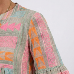 Geometric print tiered dress sleeve with pink, orange, teal shapes on gray fabric