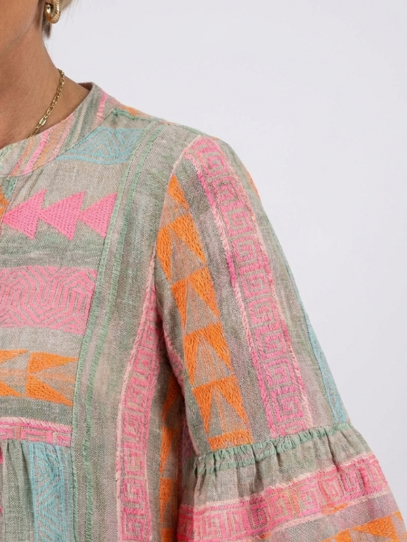 Geometric print tiered dress sleeve with pink, orange, teal shapes on gray fabric
