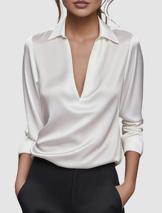 White satin blouse with pointed collar, deep V-neck, long sleeves, button cuffs.