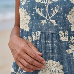 Close-up of blue midi dress fabric with cream floral print and hand