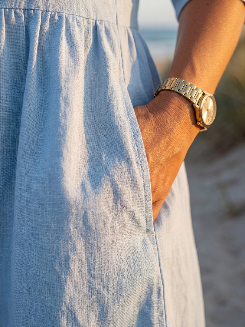 Light blue midi dress close-up: gathered fabric and hem, three-quarter sleeve