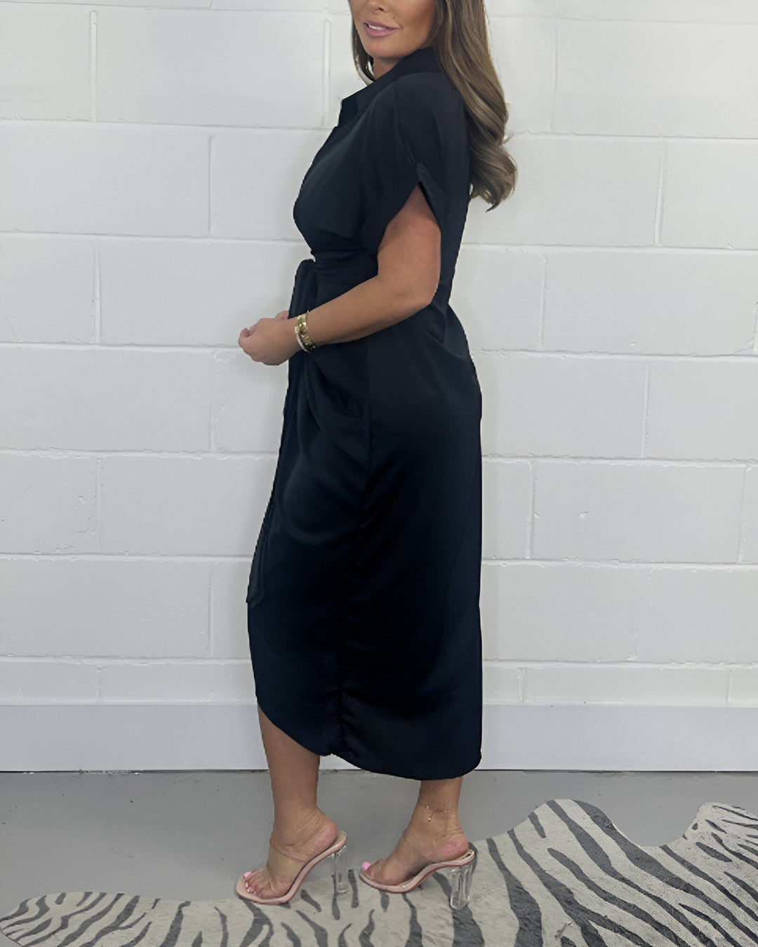 Black flared midi dress with side drape, short sleeves, and front knot detail