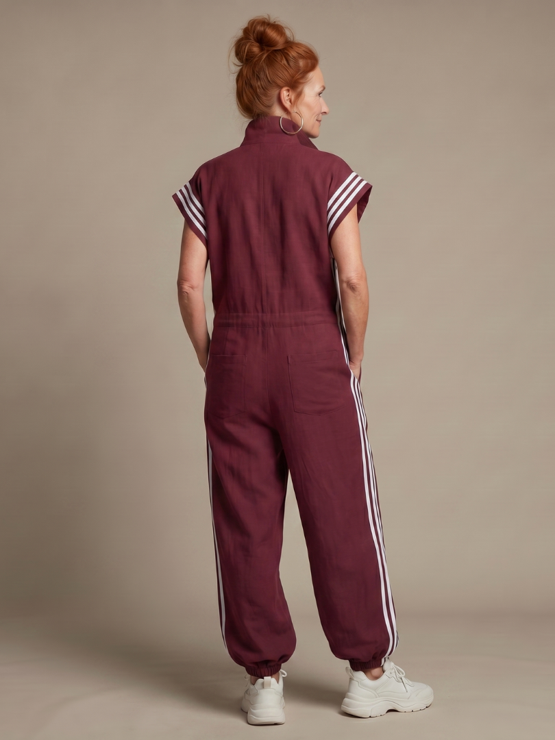 Back view burgundy zip-front jumpsuit with white striped side panels