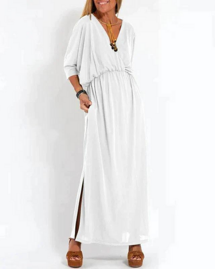 White bohemian summer dress with V-neck, elastic waist, and flowy maxi length