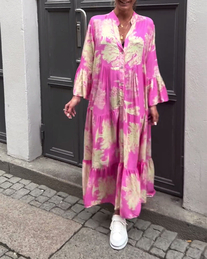 Pink flowing long dress with cream abstract blotches, long sleeves, tiered skirt.
