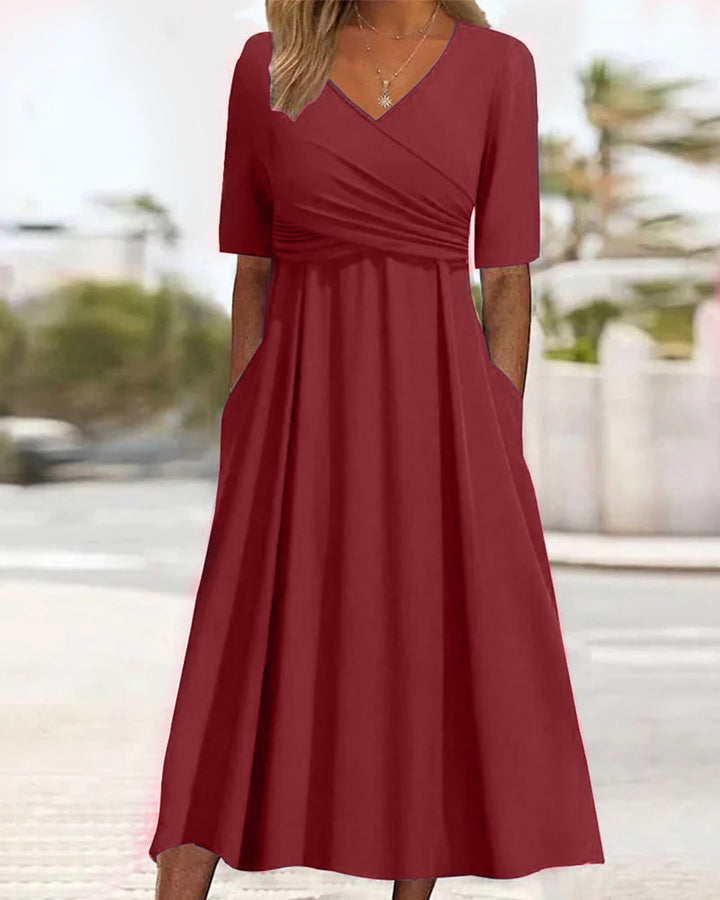 Red crossover dress with short sleeves, V-neck, gathered waist, and flared A-line skirt.
