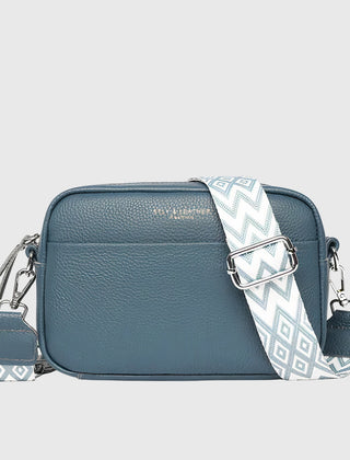 Blue leather crossbody bag with chevron strap and silver-tone side zippers