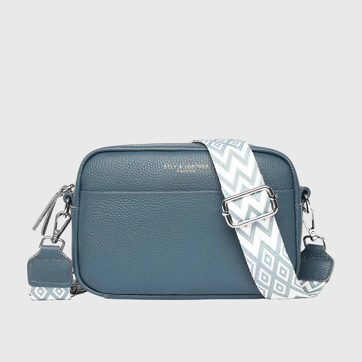 Blue leather crossbody bag with chevron strap and silver-tone side zippers