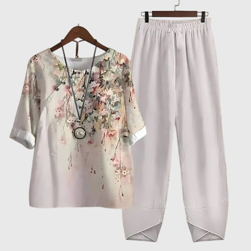 Two-piece set: white short-sleeve top and matching pants, pink floral splash design