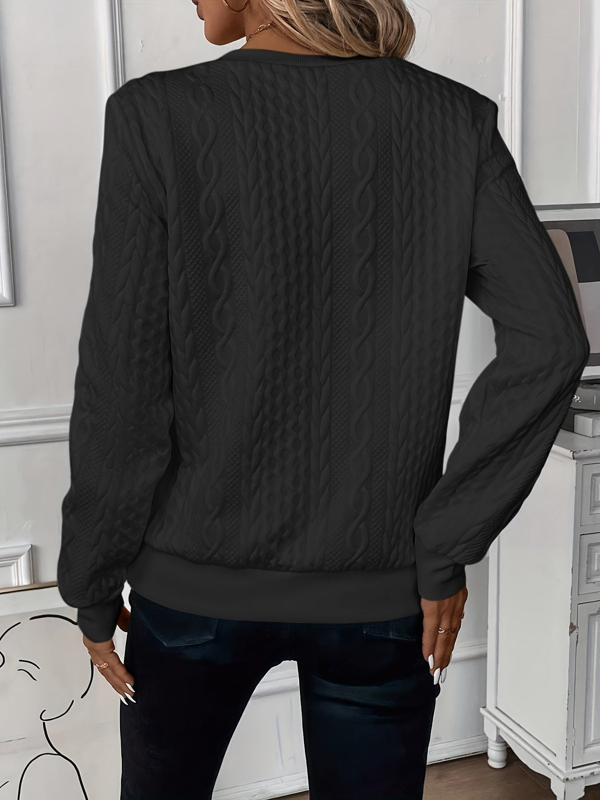 Black zip-up cable knit sweater, back view with textured pattern and ribbed cuffs