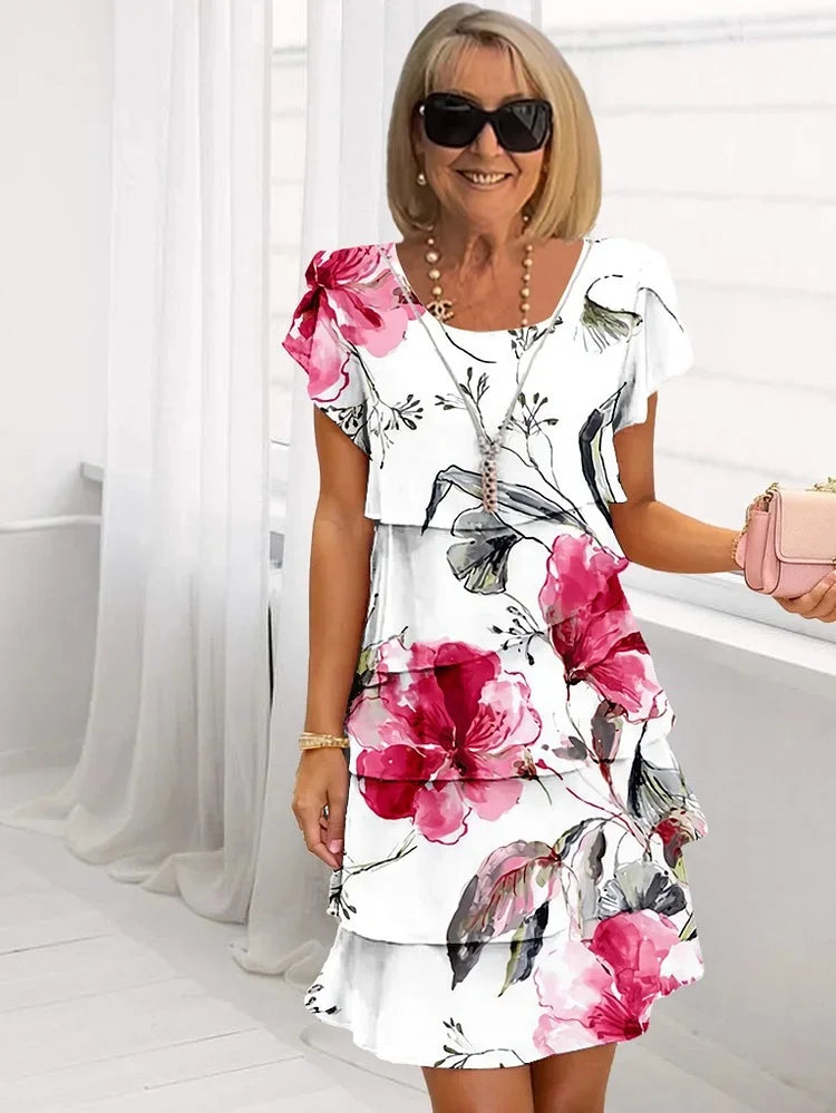 Tiered ruffled floral dress with short sleeves, white base with bold pink flowers
