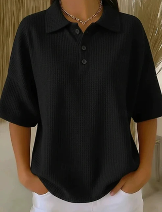 Black waffle knit polo blouse with short sleeves, pointed collar, three-button placket
