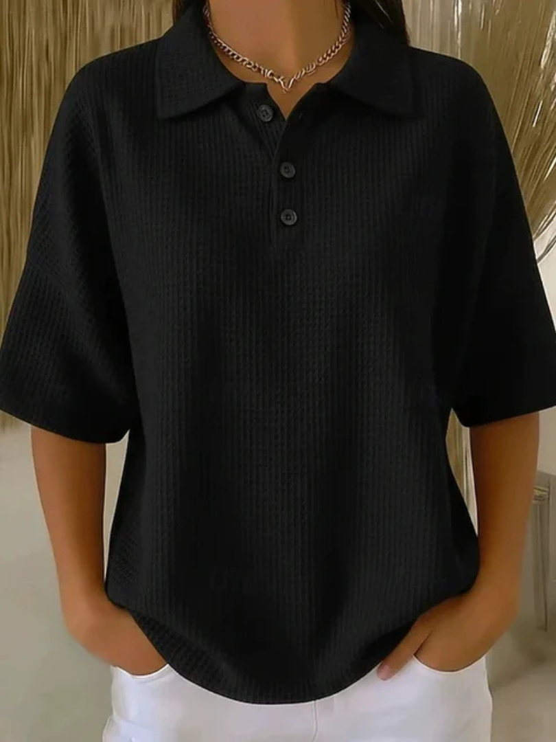 Black waffle knit polo blouse with short sleeves, pointed collar, three-button placket